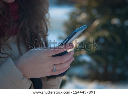 woman uses a smartphone on the street in winter