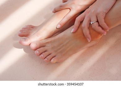 Woman Uses Two Hand Holding Swelling Pain Feet Due To Ankles Twisting.