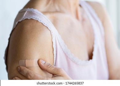 Woman Using Adhesive Bandage Plaster On Her Arm After Injection Vaccine.