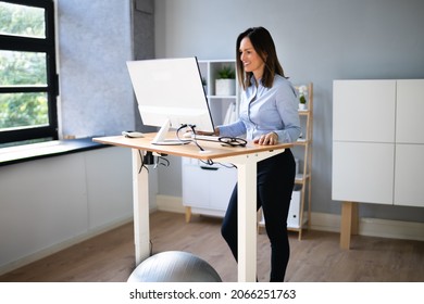 Woman Using Adjustable Height Standing Desk In Office For Good Posture - Shutterstock ID 2066251763