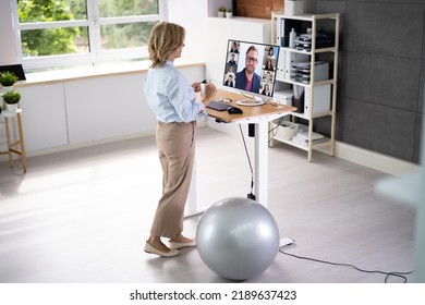 Woman Using Adjustable Height Standing Desk In Office For Good Posture