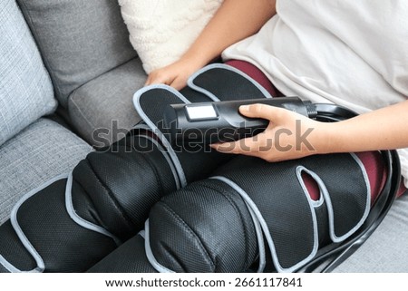 Woman using air compression leg massager at home