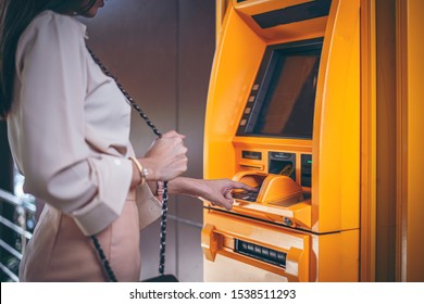 Woman Using ATM Machine To Withdraw Her Money. Close-up Of Hand Entering PIN/pass Code On ATM/bank Machine Keypad. Finger About To Press A Pin Code On A Pad. Security Code On Automated Teller Machine.