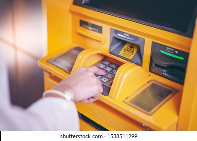 Woman Using ATM Machine To Withdraw Her Money. Close-up Of Hand Entering PIN/pass Code On ATM/bank Machine Keypad. Finger About To Press A Pin Code On A Pad. Security Code On Automated Teller Machine.