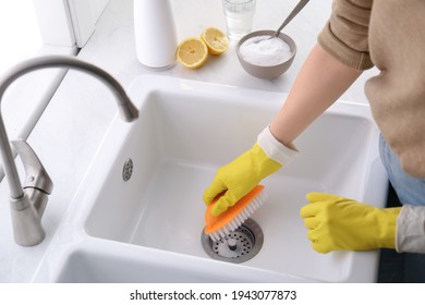 Woman Using Baking Soda And Brush To Clean Sink, Closeup