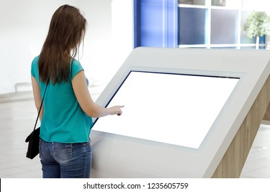 Woman Is Using A Blank Touch Screen Of Interactive Information Stand In The Supermarket.