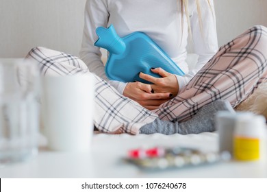 Woman using blue hot water bottle