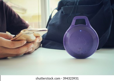 Woman Using Bluetooth Speaker With Smart Phone