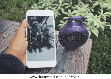 Woman using bluetooth speaker with smart phone