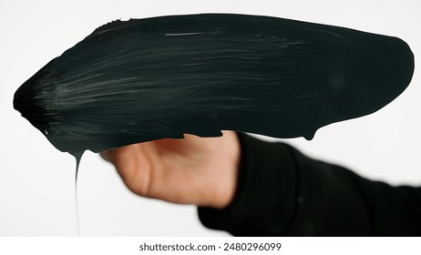 Woman using brush with acrylic oil medium black paint and drawing abstract stroke directly on glass screen isolated white background, opposite view. - Powered by Shutterstock