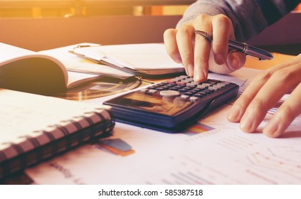 Woman using calculator with doing finance at home office.