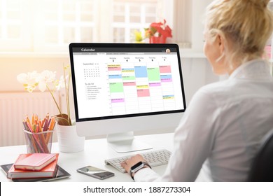 Woman Using Calendar On Computer To Organize Her Schedule At Work