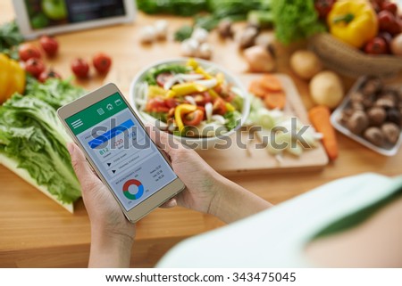 Woman using calorie counter application on her smartphone