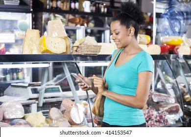 Woman Using Cell Phone In Grocery Shop