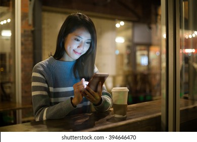 Woman using cellphone at coffee shop