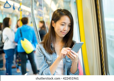 Woman Using Cellphone Inside Train Compartment