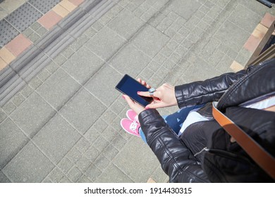 Woman using cellphone on the street. - Shutterstock ID 1914430315