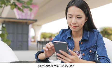 Woman using cellphone in outdoor cafe - Shutterstock ID 720251362
