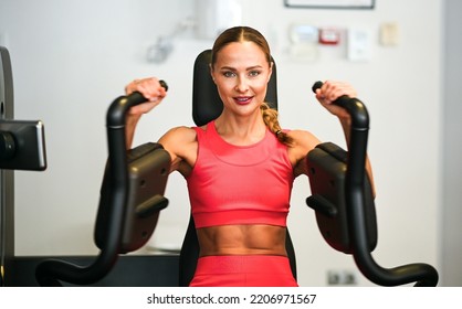 Woman Using A Chest Press Machine In A Gym