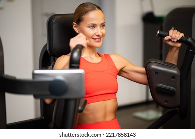 Woman Using A Chest Press Machine In A Gym