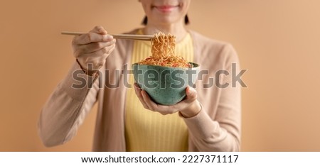 Woman Using Chopsticks to Eating Hot Boiled Instant Noodles. Cheap Asian Fast food Concepts. Front View