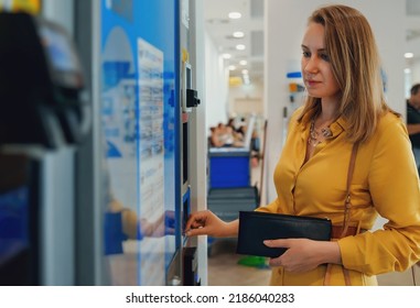Woman Using Coffee Vending Machine In Airport.