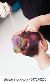 Woman Using Colorful Spray To Paint Kids Hair