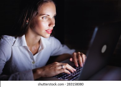 woman using computer late at night, isolated on black background