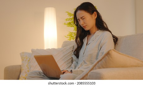 A Woman Using A Computer At Night