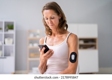 Woman Using Continuous Glucose Remote Monitor Diabetes Sensor