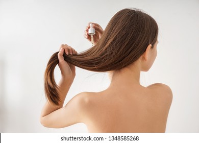 Woman Using Cosmetics For Hair Care On White Background