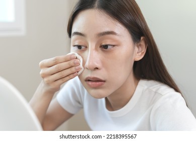 Woman Using Cotton Pad Wipe To Clean Cosmetic On Her Face