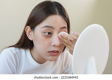 Woman Using Cotton Pad Wipe To Clean Cosmetic On Her Face