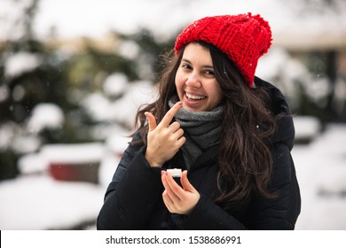 Woman Using Cream At Cold Winter Weather. Skin Protection