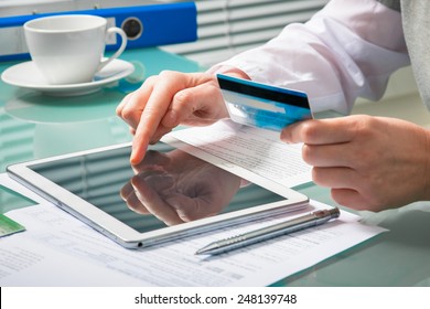 Woman Using A Credit Card And Digital Tablet For Buying Online