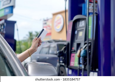 A Woman Using A Credit Card At A Gas Station