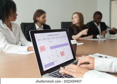 Woman using digital organizer or calendar application on laptop screen, businesswoman making events schedule with planner at office team meeting, time management and planning concept, close up view