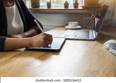 Woman using a digital pencil on ipad.