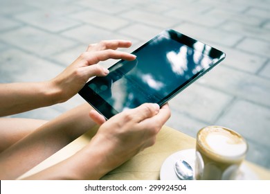  Woman Using Digital Tablet In Coffee Shop. Girl Holding A Tablet. Close Up To View Young Woman's Hands Hold Tablet                       