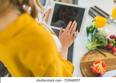 Woman Using Digital Tablet In Kitchen For Recipe   - Powered by Shutterstock