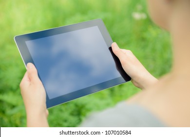 Woman using digital tablet PC in the park.