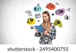 Woman using a digital tablet, surrounded by colorful social media icons on a light background. Concept of digital communication