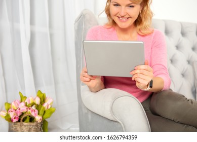 Woman using digital tablet while sitting in sofa at home