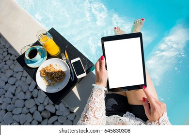 Woman using digital tablet while sitting in swimming pool - Powered by Shutterstock