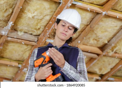 Woman Using Drill On Wall