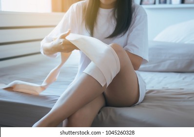 Woman Using Elastic Bandage Wrap With Leg,Female Putting Bandage On Her Injured Knee