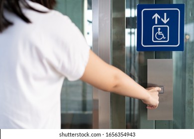 Woman using elevator in the building. Woman pressing the button on disability lift, facility and infrastructure support for disability and elder person. Concept of aging society.