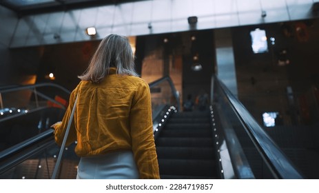 Woman using the escalator in the subway.