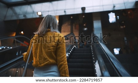Woman using the escalator in the subway.