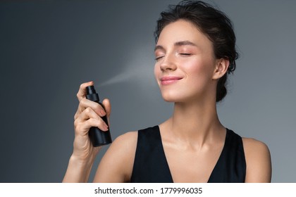 Woman using  finishing spray. Photo of woman with perfect makeup on gray background. Beauty concept - Shutterstock ID 1779996035